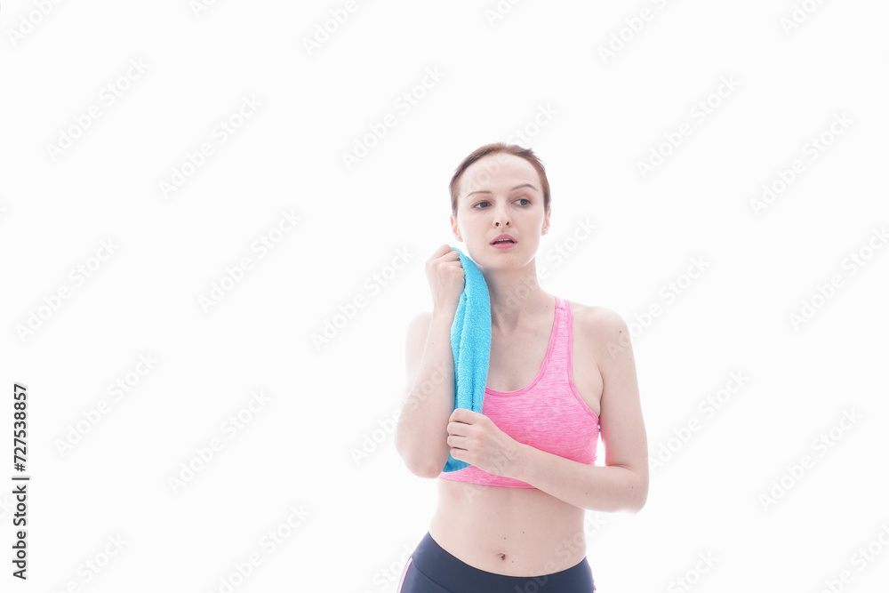 汗を拭くスポーツウェアを着た若い女性