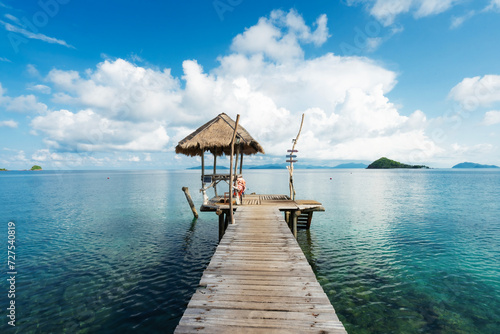 A long wooden bridge in a beautiful turquoise sea. There is a beer and beverage bar to serve tourists. Suitable for tourists to relax, fishing, diving in the East Sea at Koh Mak, Trat, Thailand. © Songsak C