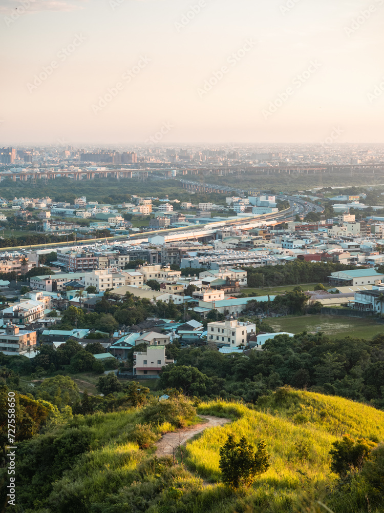 View of city from the beautiful mountain. Blue sky and green meadow.