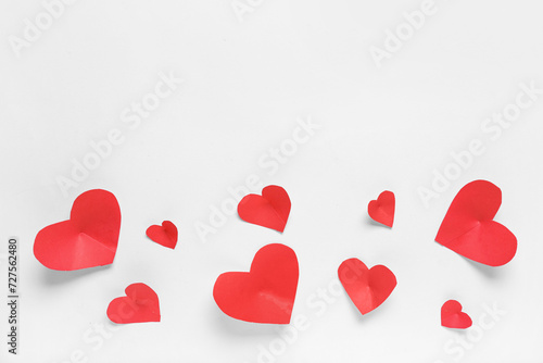 Composition with red paper hearts on light background. Valentines Day celebration