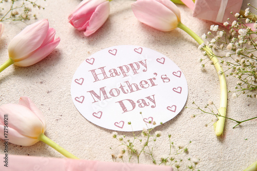 Card with text HAPPY MOTHER'S DAY and beautiful flowers on light background, closeup