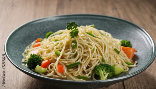 A bowl of noodles with vegetables on a wooden table
