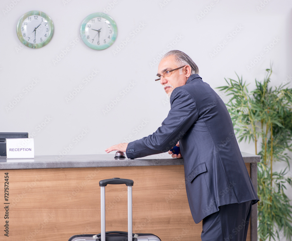 Old businessman at the hotel reception