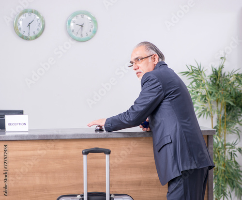 Obraz na płótnie Old businessman at the hotel reception w salonie