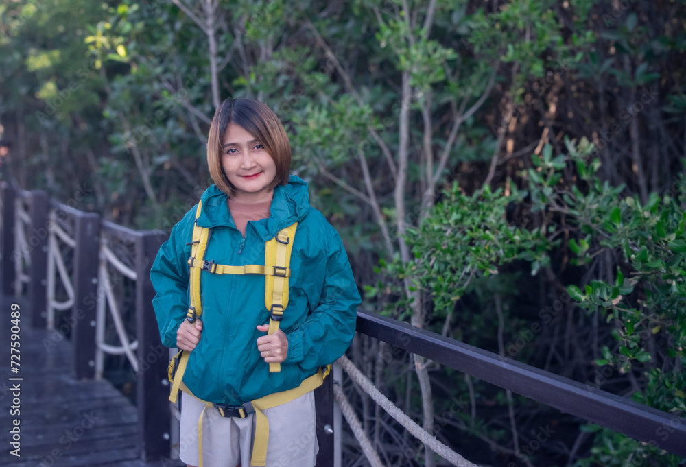 Asian woman standing on the wooden sidewalk relaxing travel nature in the mangrove forest resting on holiday vacation together,lifestyle travel concepts. Asian woman standing on the wooden sidewalk relaxing travel nature in the mangrove forest resting on holiday vacation together,lifestyle travel concepts.