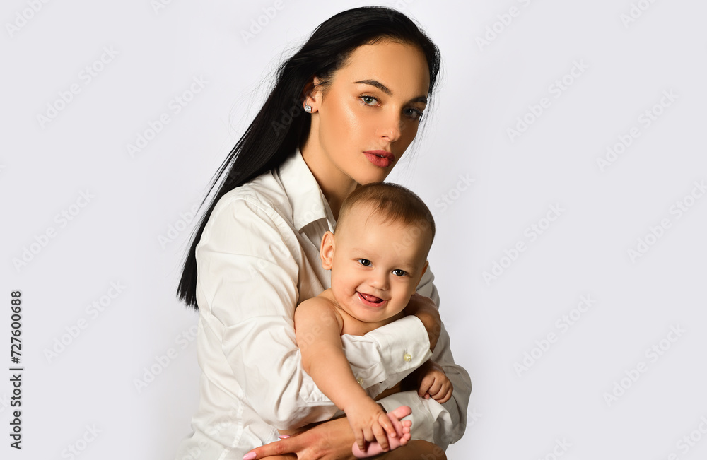 Mother hug. Closeup studio portrait of mother and baby child isolated on whtite. Mother hugging and embracing baby son. Mothers day, love family. Mother and baby child with tenderness. Mother hug. Closeup studio portrait of mother and baby child isolated on whtite. Mother hugging and embracing baby son. Mothers day, love family. Mother and baby child with tenderness.