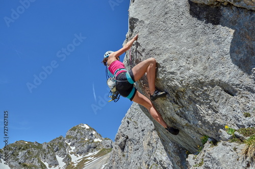 Frau klettert am Berg, Klettern an Felswand in den Alpen