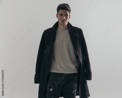 portrait of sexy young man wearing black overcoat photo
