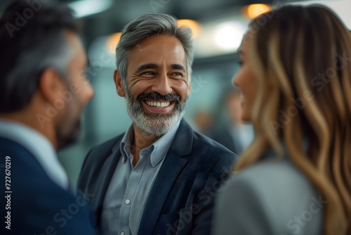 Professional businesspeople engage in lively discussion, exchanging ideas, and smiling in an office setting, showcasing teamwork and collaboration.