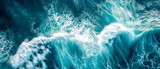 Aerial view of turbulent ocean waves with white foam.
