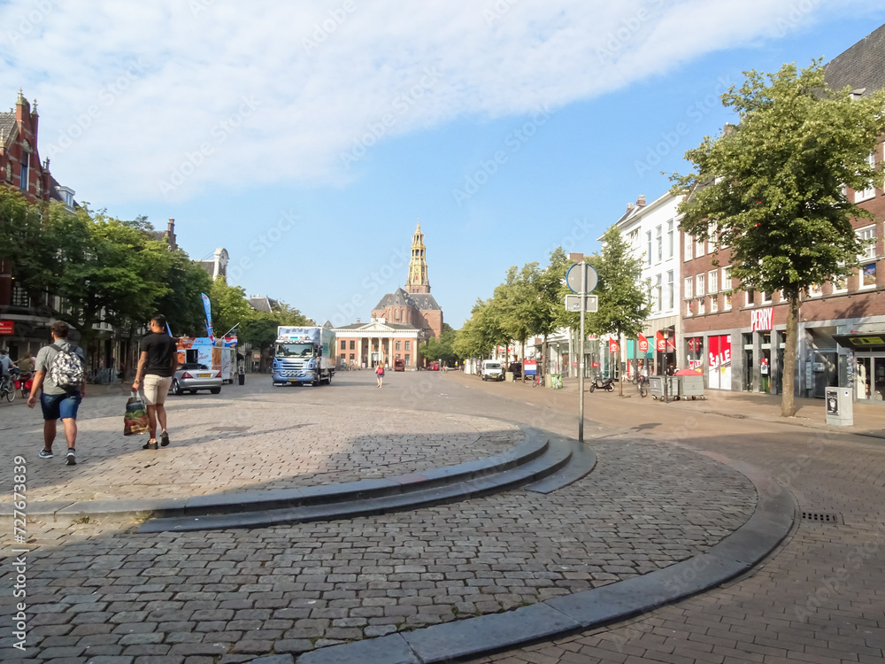 Quiet day at the market in the city center of Groningen during summer. European town architecture, buildings, shops and stores.