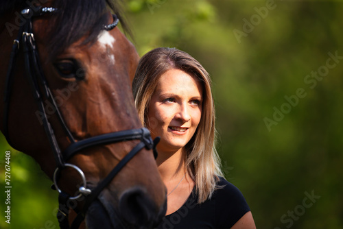Young brunette woman in head portrait next to her horse. Sharp main subject. © RD-Fotografie