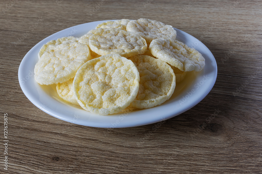 a plate of many round rice chips with cheese flavor on the table a plate of many round rice chips with cheese flavor on the table