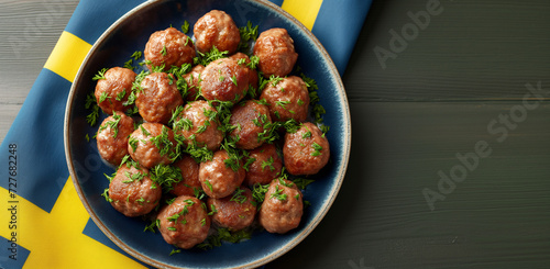 Golden brown Köttbullar, the famous meatballs, present themselves as a delicious delicacy on a traditional Swedish plate. The background of the plate reflects a Scandinavian design and Swedish colors. photo