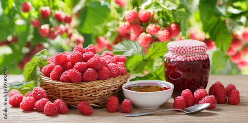   Raspberry jam and fresh fruits on wooden table in a garden