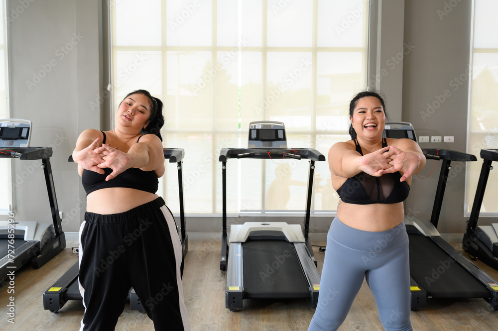 Happy Overweight Asian woman stretching before some main exercises in gym. Weight loss workout, healthy lifestyle concept. Happy Overweight Asian woman stretching before some main exercises in gym. Weight loss workout, healthy lifestyle concept.