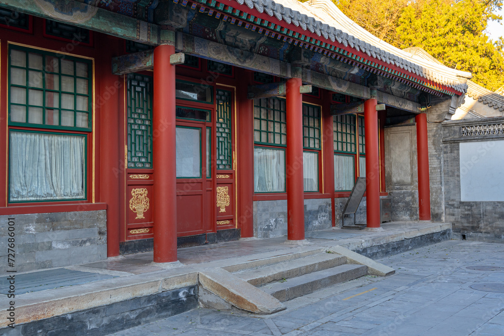 A typical traditional upper class Chinese house with common red entrance doors, red pillars, and stone staircase at the front on a sunny afternoon. A typical traditional upper class Chinese house with common red entrance doors, red pillars, and stone staircase at the front on a sunny afternoon.