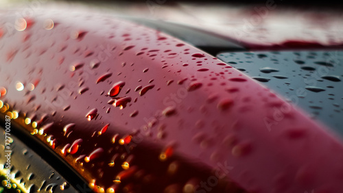 Macro de gouttes de pluie, sur la carrosserie d'une voiture rouge