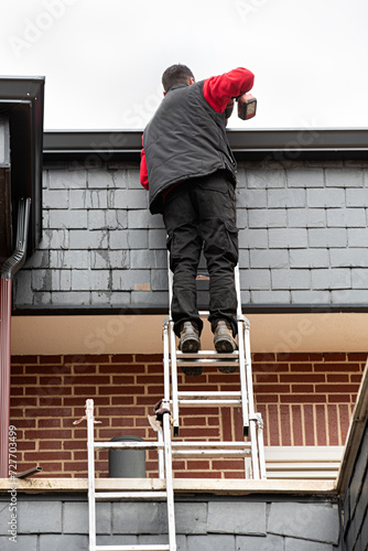 Obrero trabajando en la reparación del tejado de un chalet.