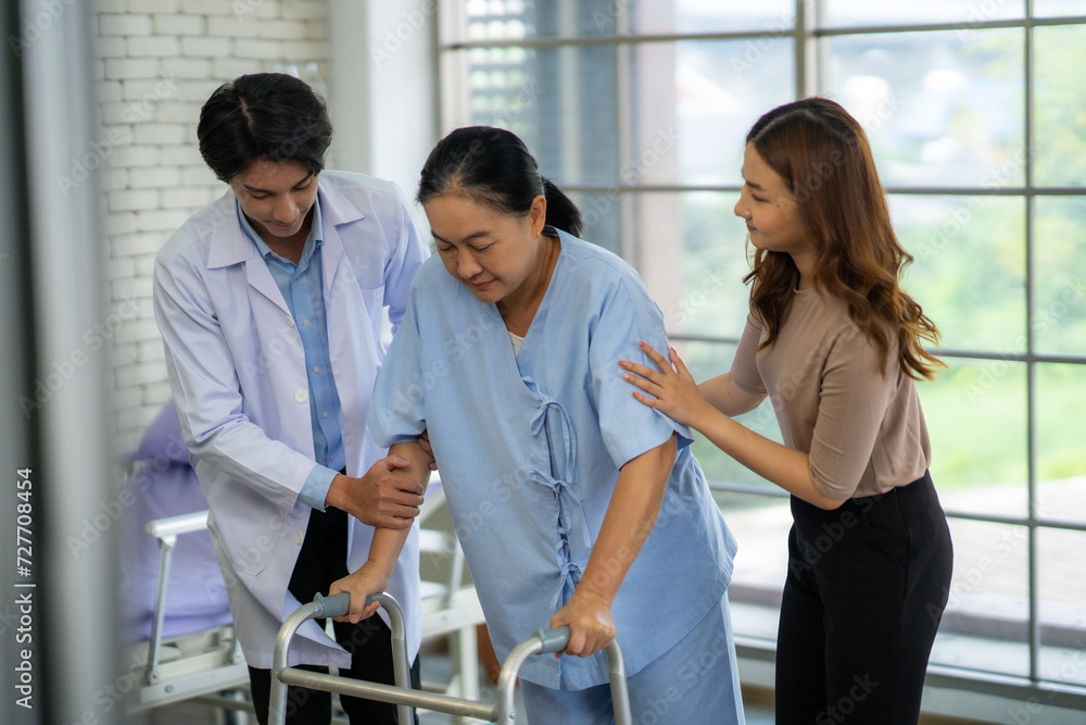 The physical therapist is assisting the patient in practicing walking, providing support for walking. The patient has pain in the ankle and a broken leg. The physical therapist is assisting the patient in practicing walking, providing support for walking. The patient has pain in the ankle and a broken leg.