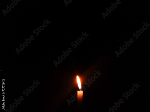a candle is lit in the dark with a match. candle in the dark. candle flame burning in the dark. power failure