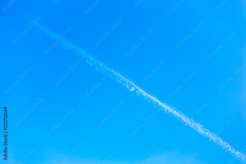 Landscape with beautiful cloudless blue sky background. with a white contrail. Beauty clear cloudy in sunlight calm bright winter or summer windy air background. Can be used as wallpaper. Landscape with beautiful cloudless blue sky background. with a white contrail. Beauty clear cloudy in sunlight calm bright winter or summer windy air background. Can be used as wallpaper.