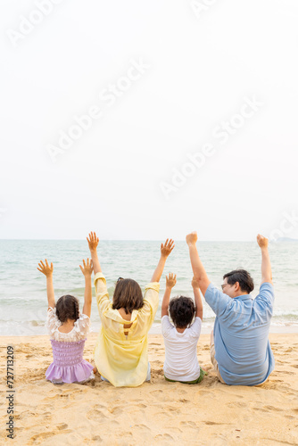 Happy Asian family enjoy and fun outdoor lifestyle travel nature ocean at tropical island beach on summer holiday vacation. Parents and little kids relaxing and playing together on the beach at sunset