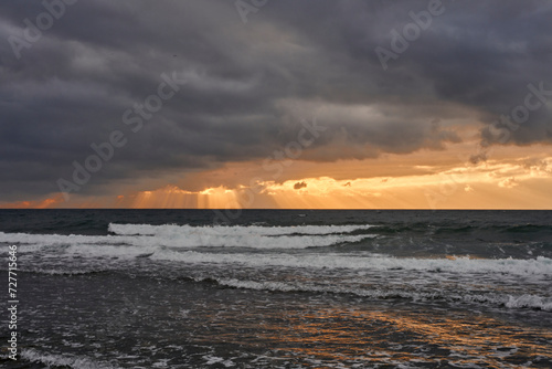 amanecer con nubes de tormenta en una playa turística del mediterráneo 