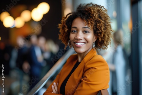 A portrait of a confident woman smiling and leaning on a handrail while at a business conference. 