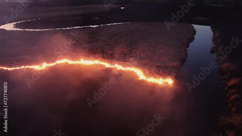 Aerial Nighttime View of Fire Encroaching on Waterway photo