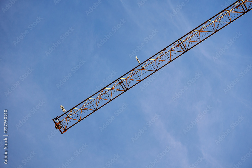 Low angle of a construction crane against the blue sky