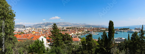 An unforgettable view of Split City, encompassing architecture, hills, trees, the sea, and boats.