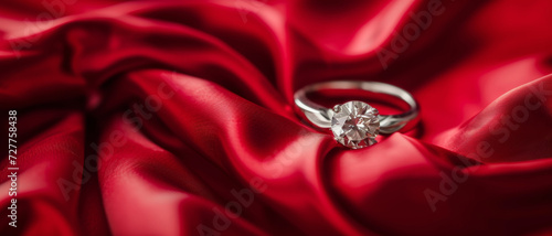 Solitaire diamond ring nestled in folds of red silk, symbolizing romance and timeless elegance