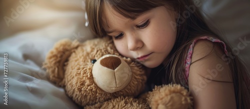 Adorable Little Girl Finds Comfort Hugging Her Beloved Stuffed Animal Toy photo