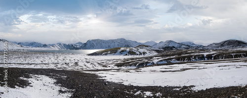 Season changing in southern Highlands of Iceland. Colorful Landmannalaugar mountains under snow cover in autumn. Frostastadavatn lake at the foot of the mountains. photo