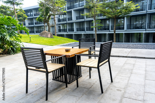 An Outdoor Dining Table Set with a View of Trees, Green Grass, and Series of Balconies