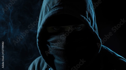 Criminal wearing black balaclava and hoodie in the dark