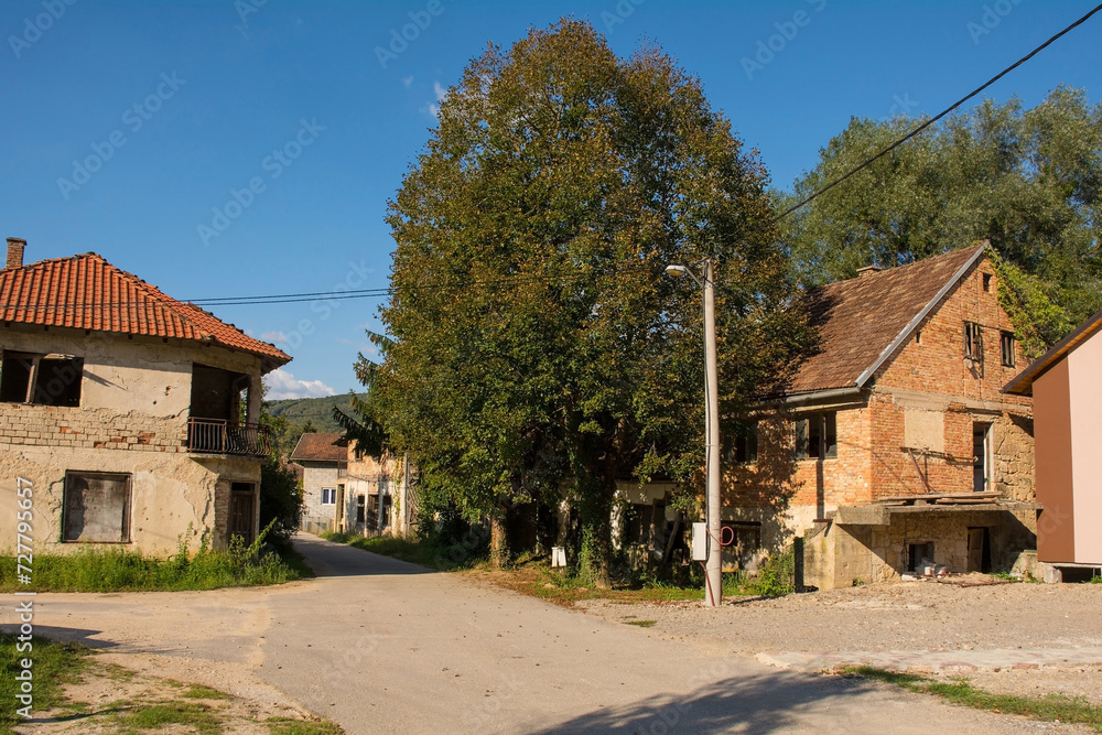 Derelict houses on the edge of Kulen Vakuf Village in the Una National Park. Una-Sana Canton, Federation of Bosnia and Herzegovina. Early September Derelict houses on the edge of Kulen Vakuf Village in the Una National Park. Una-Sana Canton, Federation of Bosnia and Herzegovina. Early September