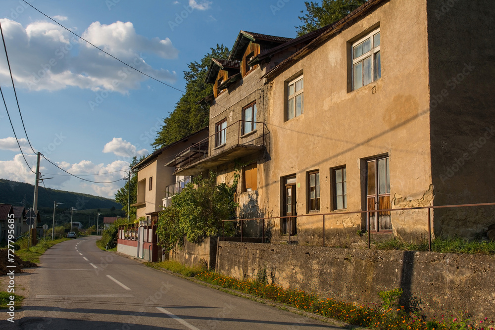 A quiet residential road in Kulen Vakuf village in the Una National Park. Una-Sana Canton, Federation of Bosnia and Herzegovina. The buildings foreground right are abandoned. Early September