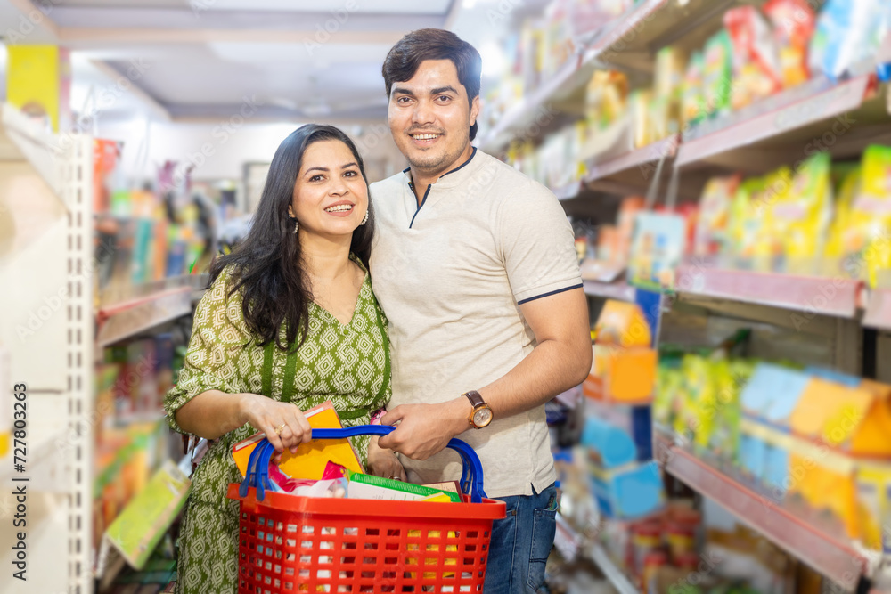 Indian couple shopping for groceries at the supermarket. Buying grocery for home.