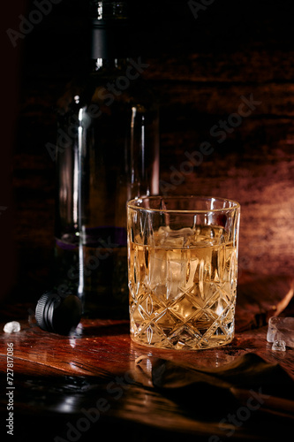Whisky in a glass with ice on rustic wood