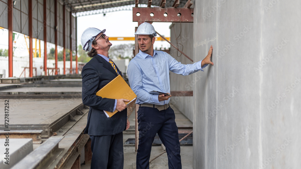 Two engineers from different cultures work closely together to conduct qualify control for their readymade floor or wall in a factory Two engineers from different cultures work closely together to conduct qualify control for their readymade floor or wall in a factory