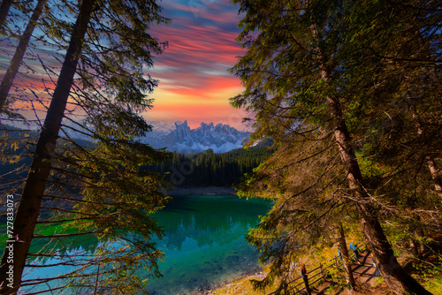 Lago di Carezza, an alpine marvel with emerald waters, cradled by spruce trees, framed by the majestic Dolomites, a fairy tale woven into nature's enchanting panorama photo