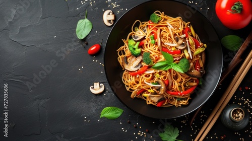 Delicious asian noodles with vegetables and mushrooms on dark background . Top view copy space