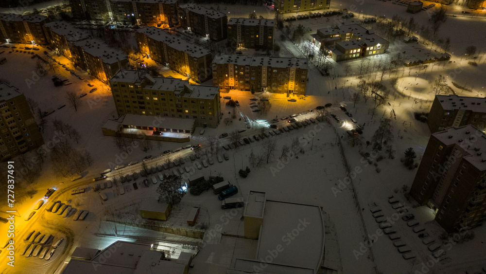 Drone photography of parking place near a building and snow covered cars during winter morning