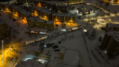 Drone photography of parking place near a building and snow covered cars during winter morning © M