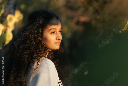 Obraz na płótnie Dreamy scene. A closeup of 13 years old girl watching the sunset through the trees and sunlight touching on her face w salonie