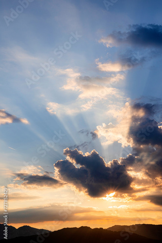 sunset in the mountains with storm clouds and sun rays