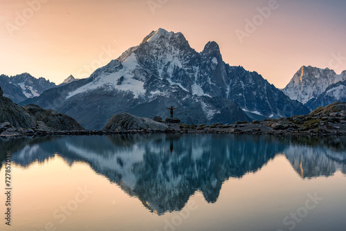 French alps landscape of Lac Blanc with Mont Blanc massif with male traveler reflected on the lake at Chamonix, France