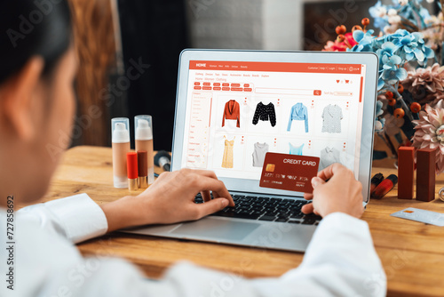 Woman shopping online on internet marketplace browsing for sale items for modern lifestyle and use credit card for online payment from wallet protected by uttermost cyber security software photo